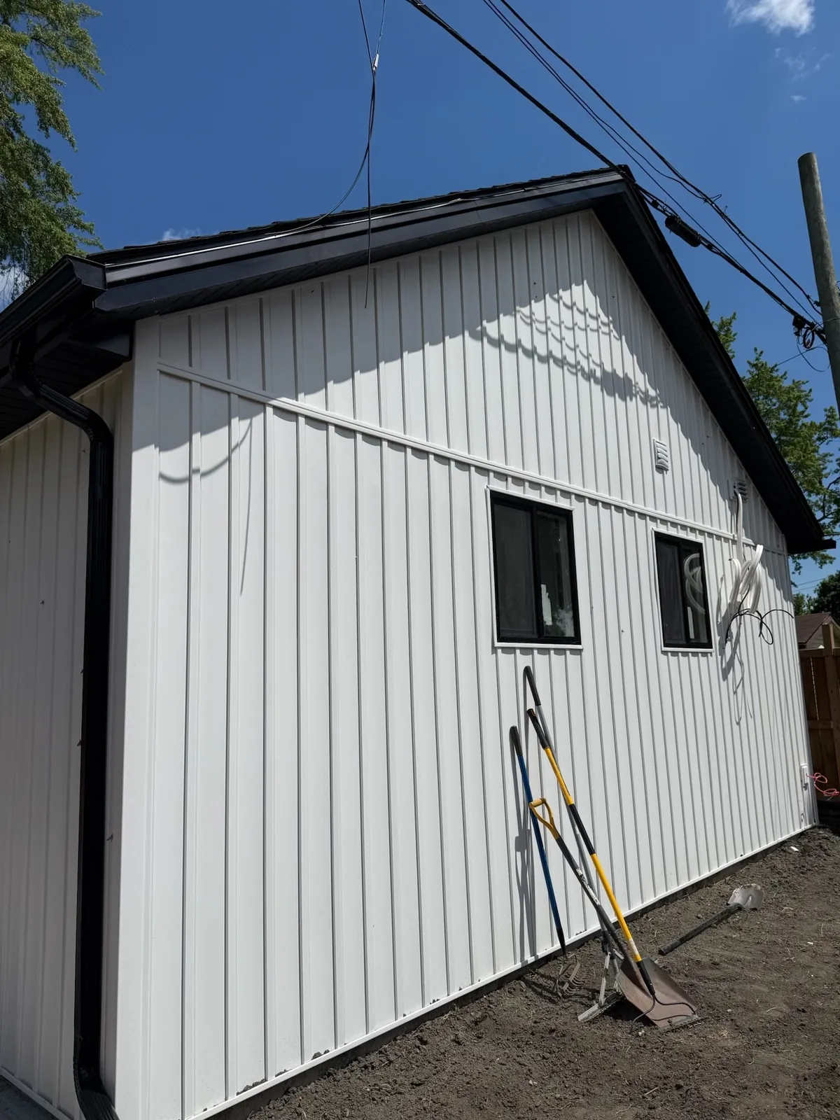 White vertical siding with dark trim on a residential exterior